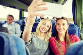 women taking selfies at travel bus